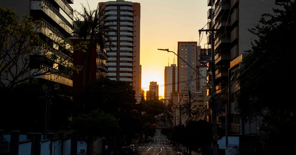 Rua de cidade ao entardecer com prédios