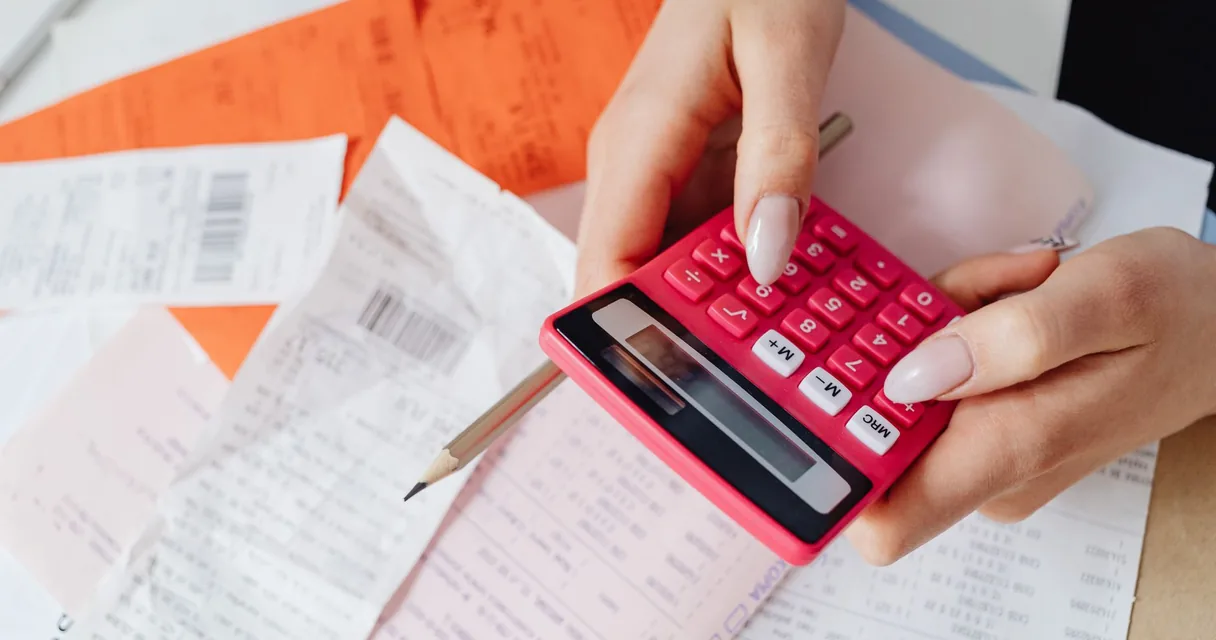 Notas fiscais e calculadora sobre uma mesa